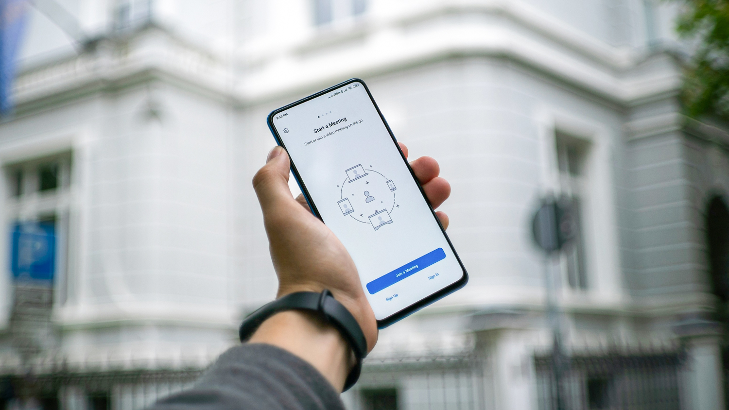 Hand holding phone preparing to start meeting